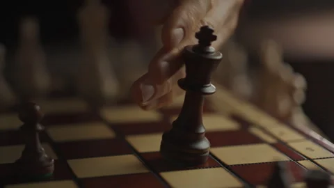 Defeat of the King A young but experienced chess player knocks over a king's Stock Footage 331289006