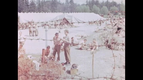 Defeated troops wait behind barbed wire Stock Footage 103377340