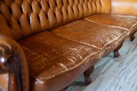 Defects on a leather sofa. Damaged to leather furniture. Stock Photos
