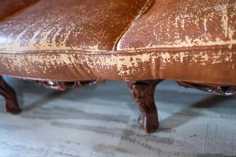 Defects on a leather sofa. Damaged to leather furniture. Stock Photos
