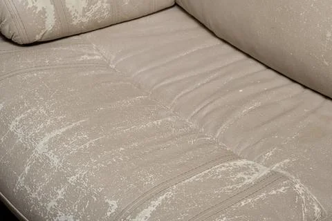 Defects on a white leather sofa. Damaged to leather furniture. Stock Photos