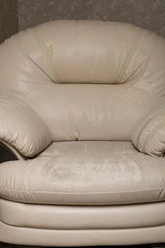Defects on a white leather sofa. Damaged to leather furniture. Stock Photos