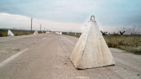 Defensive war concrete structures on the road. Anti-tank hedgehogs Stock Footage 260630957