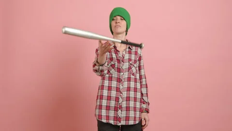Defiant Young Lesbian with Baseball Bat and Casual Plaid Attire Against Pink Stock Footage 264121201