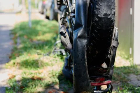 Deflated inner tube pulled out of a fat bike flat tire on the street Stock Photos