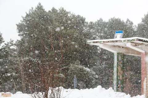 Defocus abstract blurred winter background. Vintage bus stop in snowstorm. Co Stock Photos