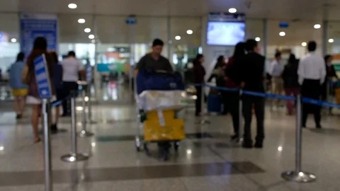 Defocus of arrival Terminal and arriving passengers with luggages cart Stock Footage 97792286