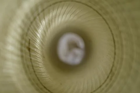 Defocus, blur, noise, grain effect. Inside a roll of white plastic mesh. Buil Stock Photos