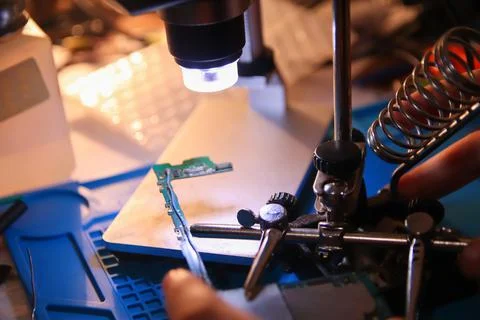 Defocus closeup microscope. Work with a soldering iron. Microelectronics devi Stock Photos