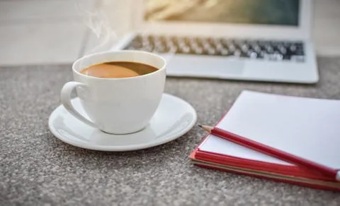 Defocus coffee cup on ground with notebook and laptop,morning,hot coffee Foto stock