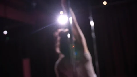 Defocus dancing near the pylon. A dark studio, a spotlight shines in the camra Stock-Footage 118905942