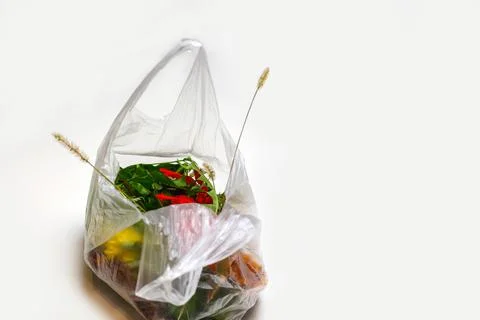 DEFOCUS. Ecological problem. Red and green plants flowers in a plastic bag on a 写真素材