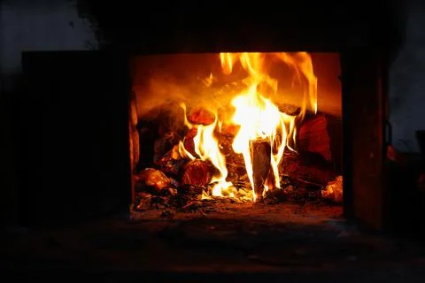 Defocus fire flame background. Firewood burning in old stove or oven. Dark an Stock Photos