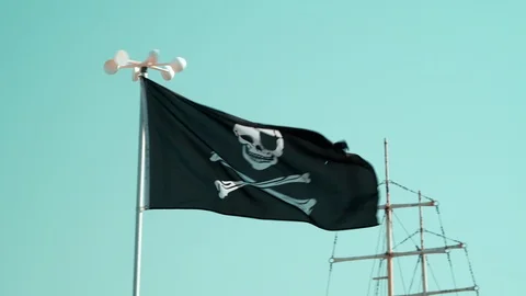 Defocus in focus slide black pirate flag with Jolly Roger against blue sky Видео 91597281