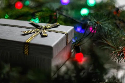Defocus gray gift with gold bow ribbon on natural fir tree blurr Stockfoto's