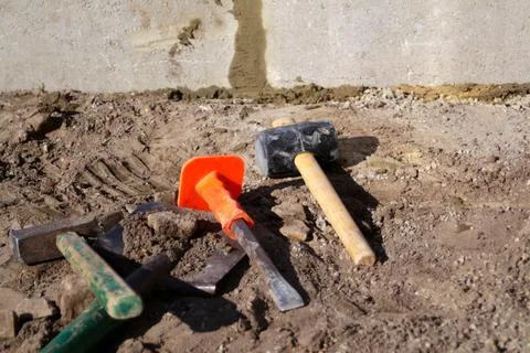 Defocus hammer, mallet, chisel and bayonet of the shovel lie on the ground. S Foto stock
