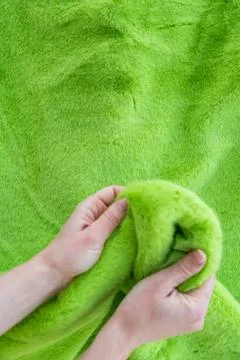 Defocus hands touching soft green faux fur, textile texture and fabric concept Stock Photos