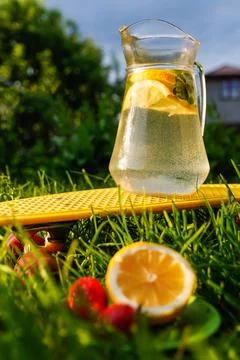 Defocus jug of lemonade with slice lemon and leaves of mint on yellow board n Stock Photos
