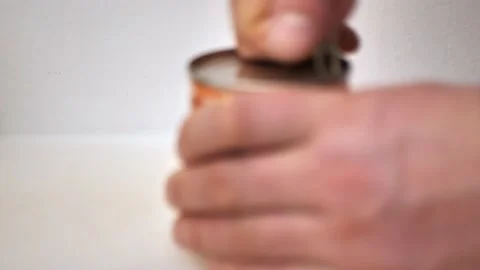 Defocus. a man opens a tin can Stock Footage 158039845