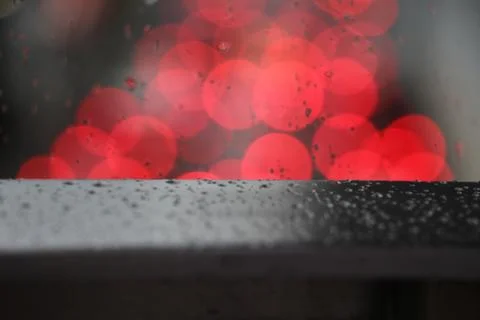 Defocus red light blurred background on surface glass with rain drops Stock Photos