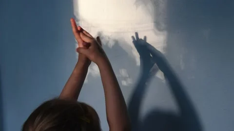 Defocus shadows of kid hands on stucco wall surface with copy space. Halloween Stock Footage 141945784