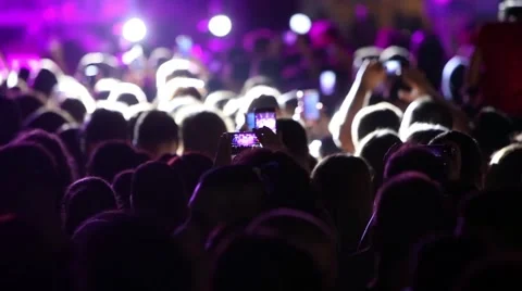 Defocus silhouettes of concert crowd in front of bright stage lights Stock Footage 67537600