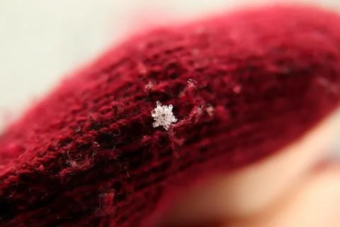 Defocus snowflake on a dark red background. Beautiful Macro snowflake, everyo Stock Photos