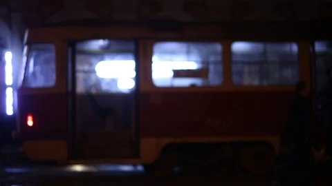 Defocus, soft focus. night city, city traffic, tram closes the door and drives o Stock Footage 74374882