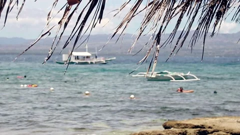 Defocus of a tropical beach scene with outrigger boats or bangka moored in Video stock 312304071