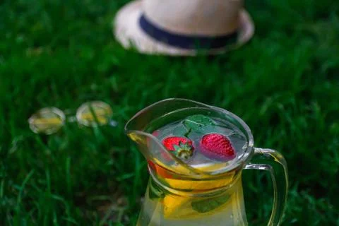 Defocus two strawberry, slice lemon and leaves of mint in glass jug of lemona Stock Photos
