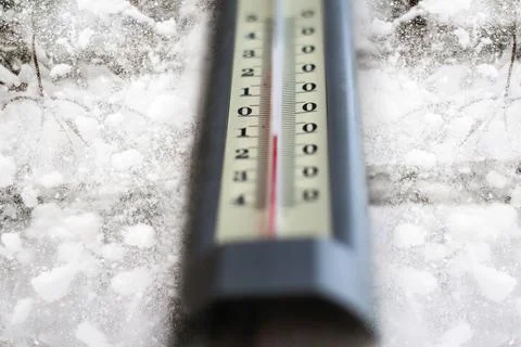 Defocus winter thermometer. Winter time. Thermometer on snow shows low temper Photos