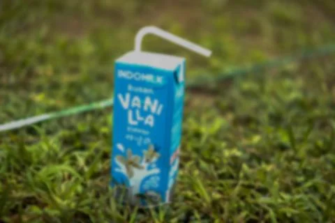 Defocused abstract background of blu box milk in grass Stock Photos