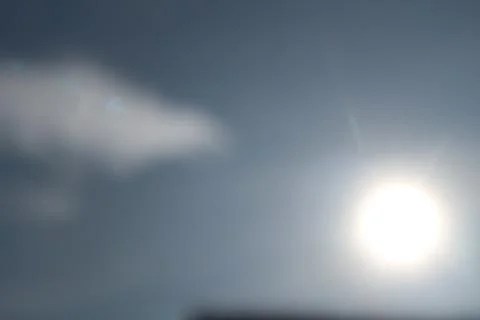 Defocused abstract background of cloudy sky and sun Stock Photos