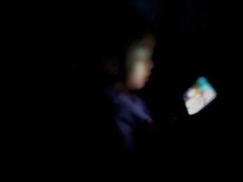 Defocused abstract background featuring a child engaged with a smartphone Stock Photos