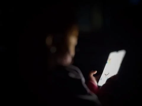 Defocused abstract background featuring a child engaged with a smartphone Stock Photos