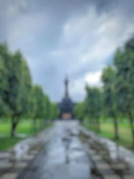 Defocused abstract background of Green trees and grass in a city park. Stock Photos