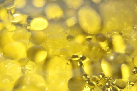 Defocused abstract background with yellow bubbles of oil in water. Macro phot Stock Photos