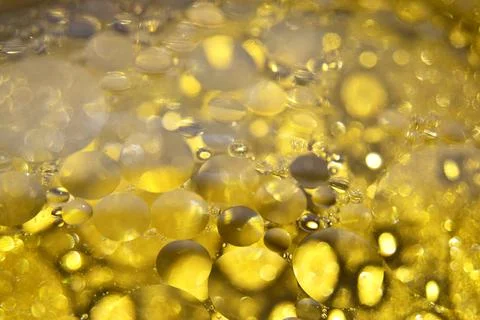 Defocused abstract background with yellow bubbles of oil in water. Macro phot Stock Photos