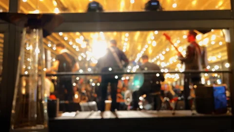 Defocused background: Band is performing at a restaurant at night with yellow Video stock 241535306