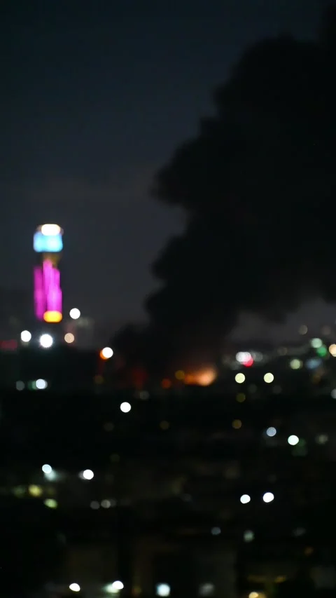 Defocused background of factory catched a fire with lots dark smoke at night Stock Footage 248432150