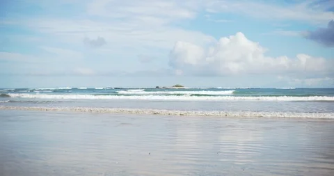 Defocused background plate of cloudscape and sea waves breaking on sandy beach Stock-Footage 95613102