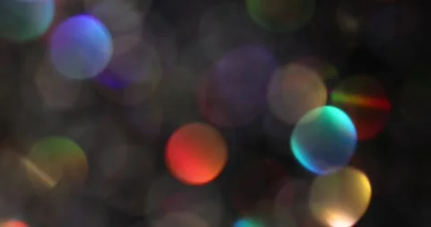 Defocused bokeh colored particles inside a glass Christmas ball.	 Video stock 168181640