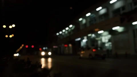 A defocused car drives down a night street Stock Footage 230104383