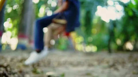 Defocused children having fun swinging in a playground Stock Footage 312689980