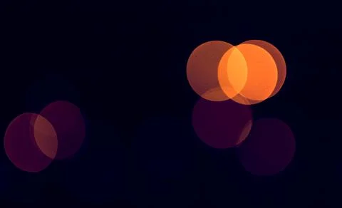 Defocused circular light spots clustered on dark background with visible ov.. Stock Photos