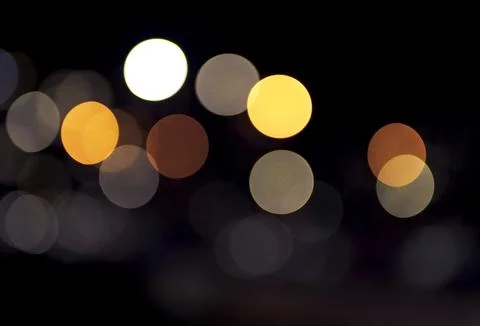 Defocused circular light spots scattered across dark background with visible Stock Photos