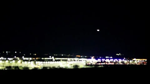 Defocused city lights glow against a night sky, abstract urban landscape Stock Footage 260086643
