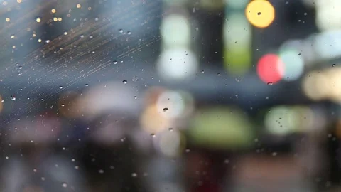 Defocused commuters in the background of raindrops collecting on the window. Vídeos de archivo 77127795