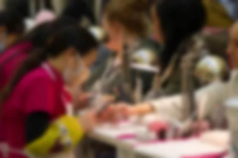 Defocused customer having her nails filed by a professional manicurist Stock Photos