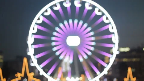 Defocused ferris wheel attraction illuminated at night Stock Footage 99472007